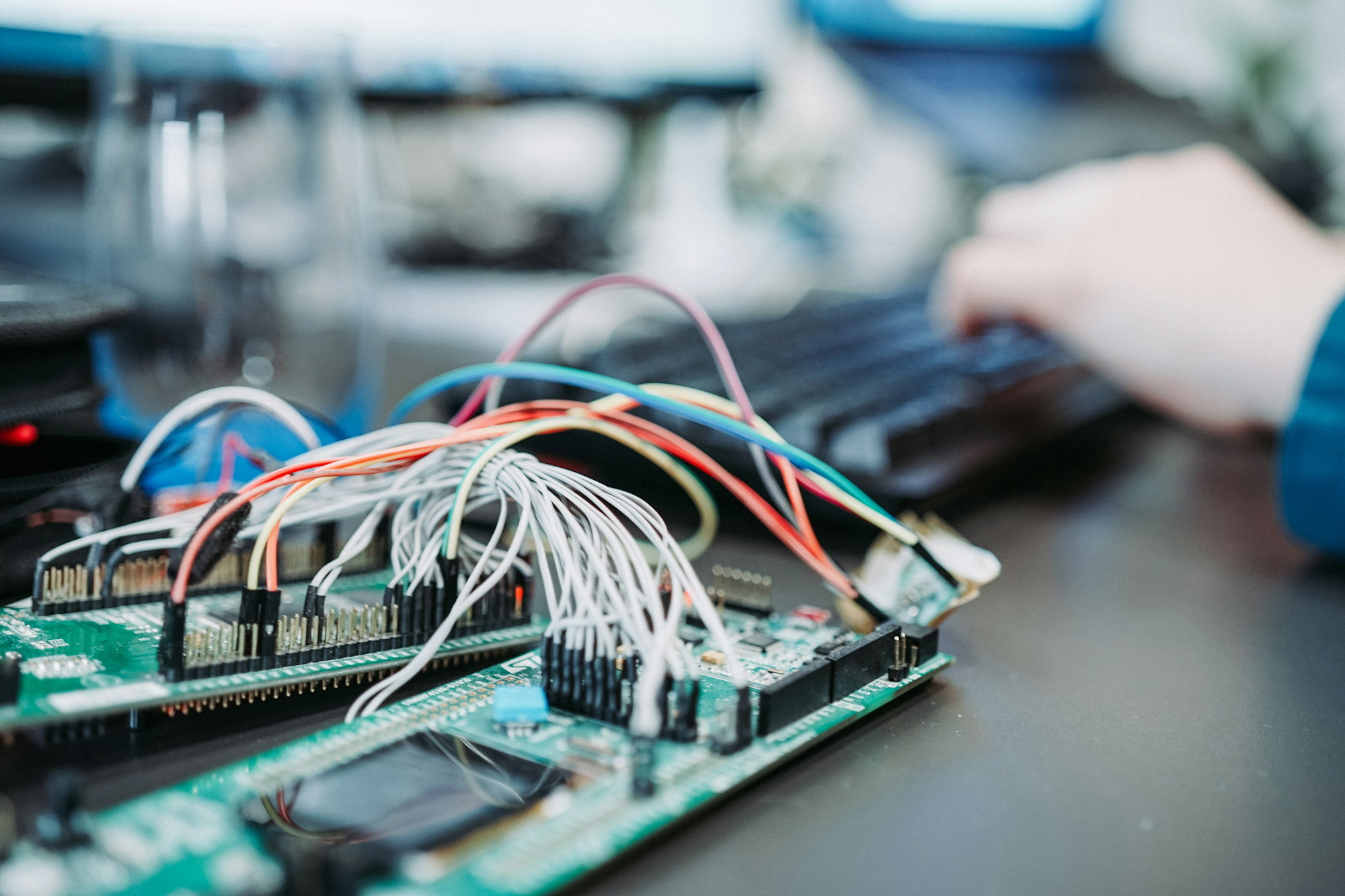 person-using-computer-keyboard-near-green-circuit-board.jpg person using computer keyboard near green circuit board